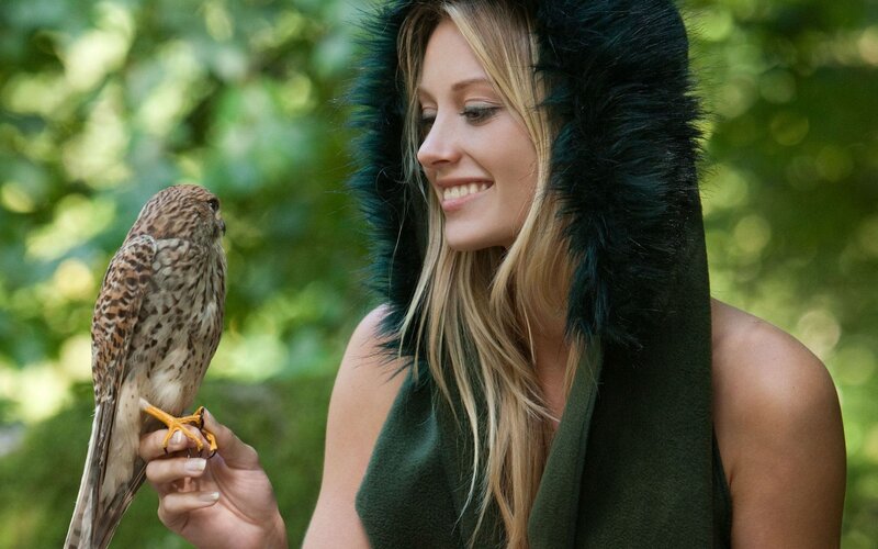 Woman with falcon in forest