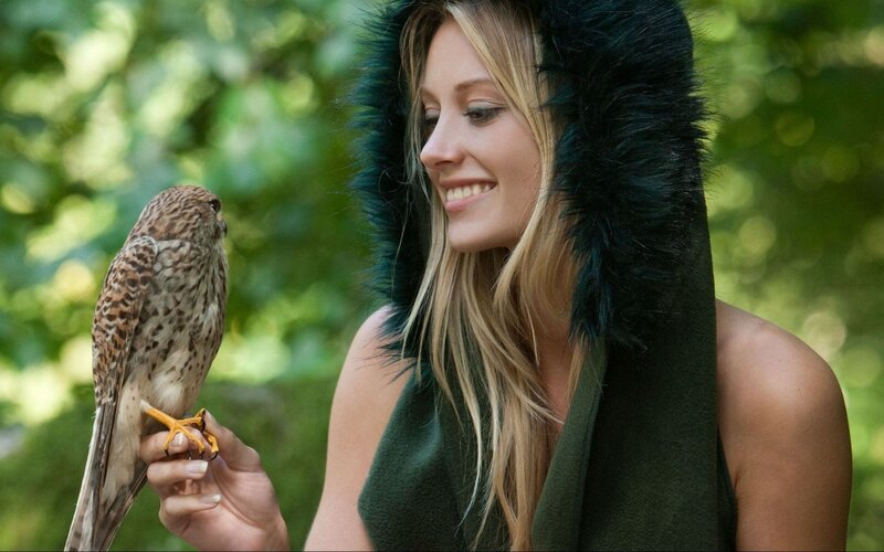 Woman with falcon in forest