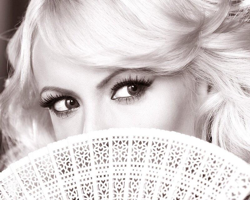 woman with fan covering face