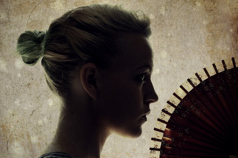 woman with fan in profile