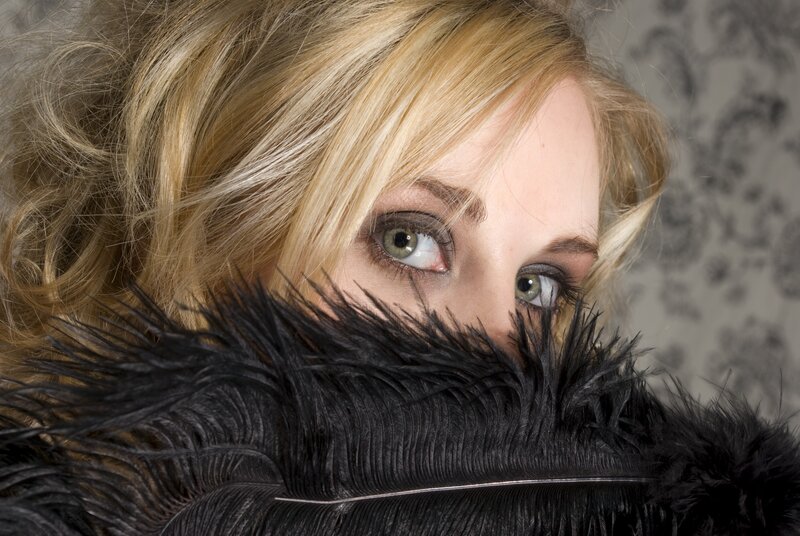 woman with feather covering face