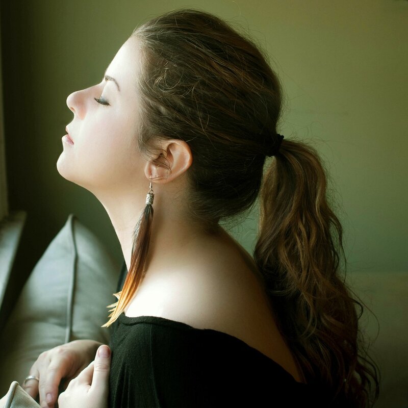woman with feather earring in profile