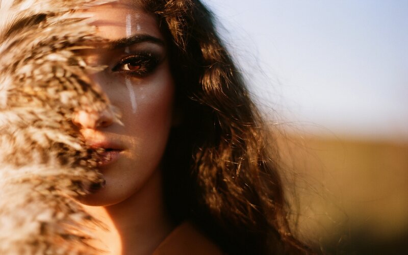 woman with feather in field