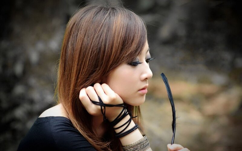 woman with feather in hand