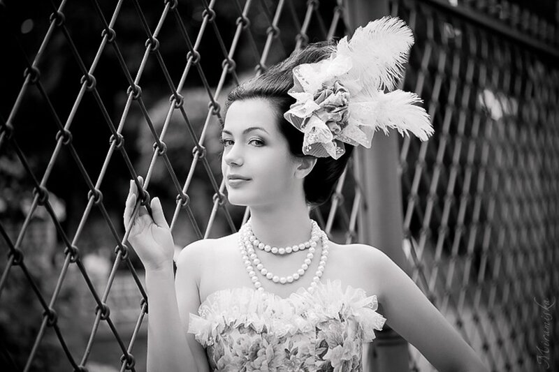 Woman with Feathered Hat — Black, Dramatic, Photograph, Chain-link Fence