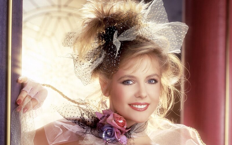 woman with feathered hat smiling