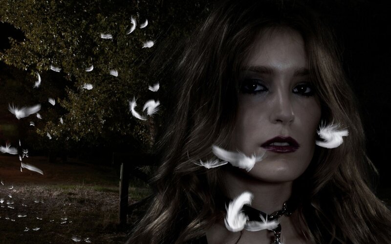 woman with feathers in dark forest