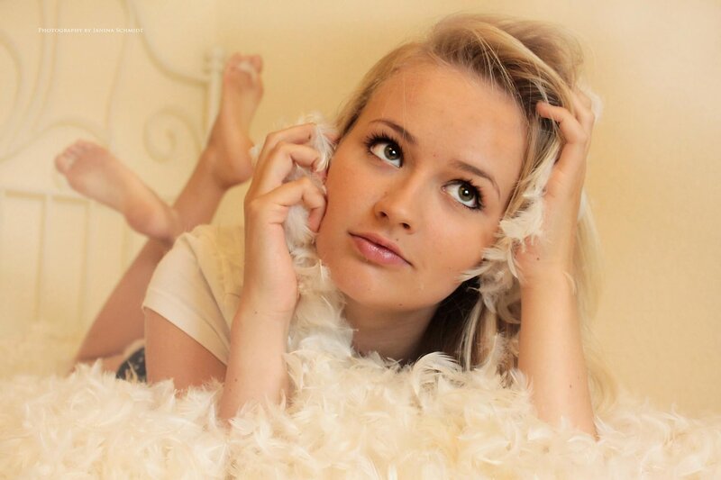 woman with feathers on bed