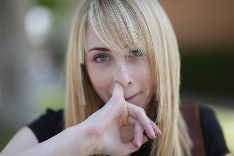 woman with finger to nose