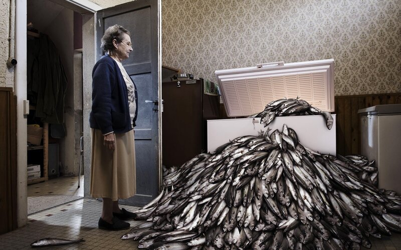 Woman with fish pile in kitchen