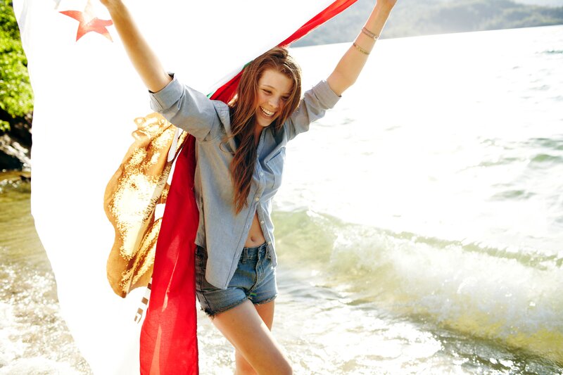 Woman with flag at the beach