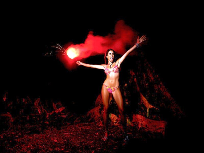 Woman with flare in dark forest