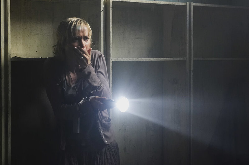 Woman with flashlight in dark room