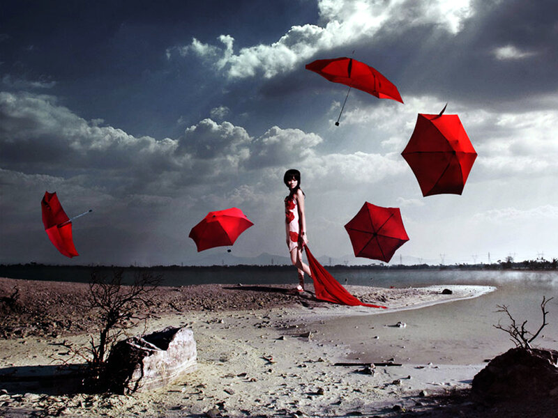 Woman with floating red umbrellas