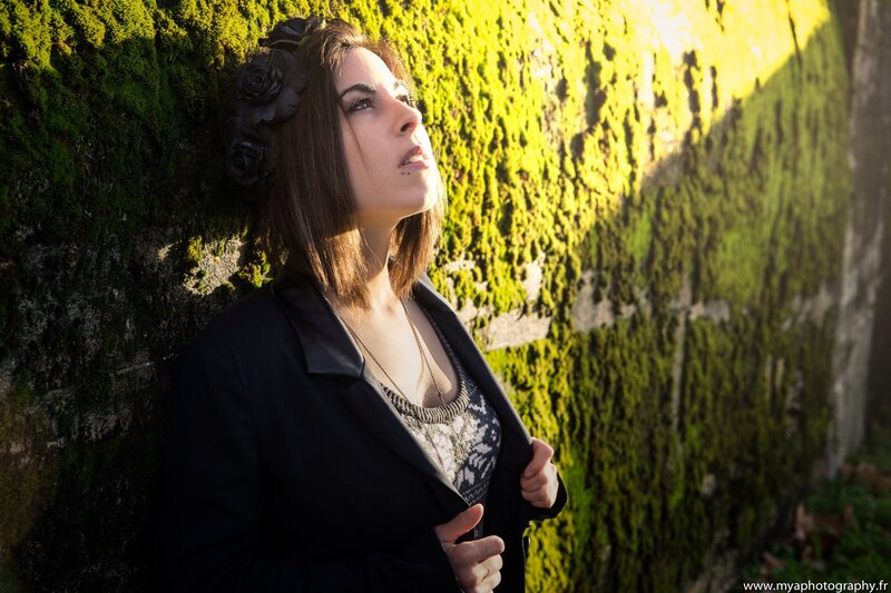 woman with flower crown against moss wall