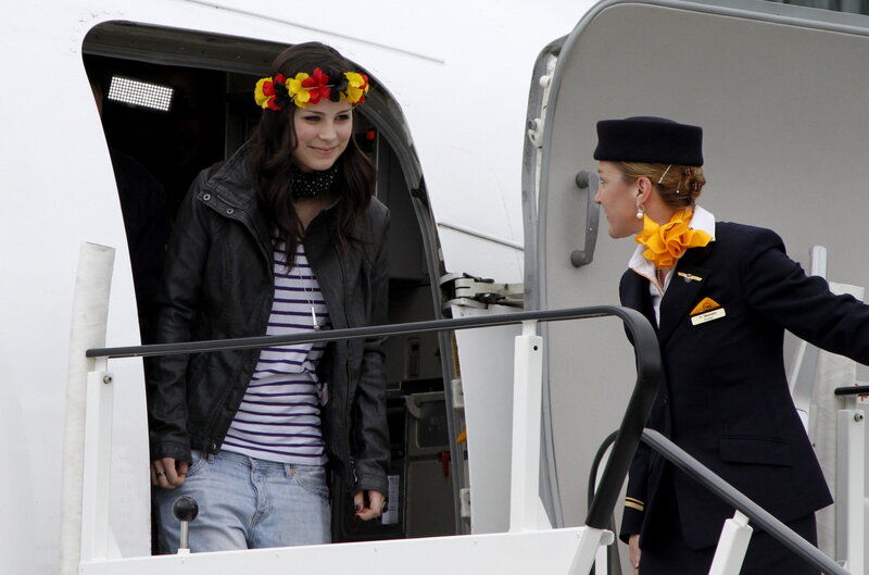 Woman with flower crown disembarking plane