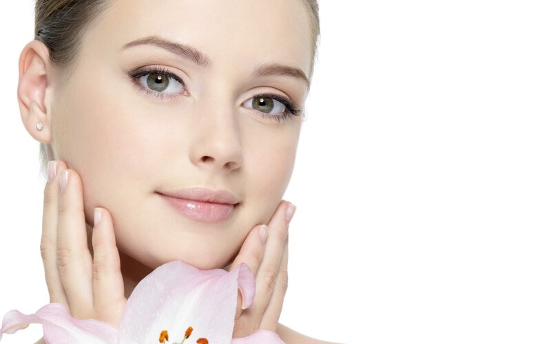 woman with flower holding face
