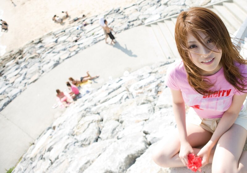Woman with flower on rocky beach