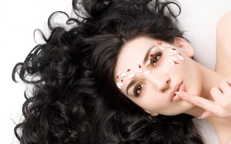 woman with flower petals on face
