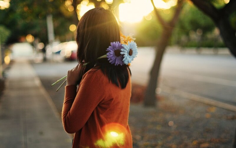 woman with flowers at sunset
