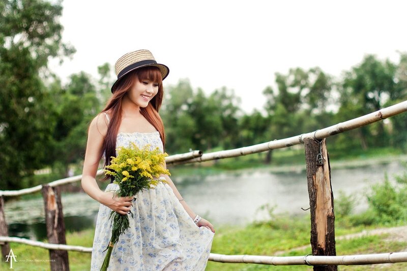 Woman with flowers by a pond