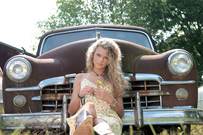 woman with flowers by old car