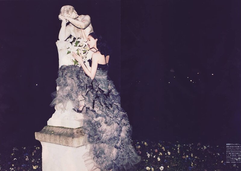 woman with flowers near statue