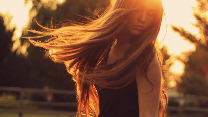 woman with flowing hair at sunset