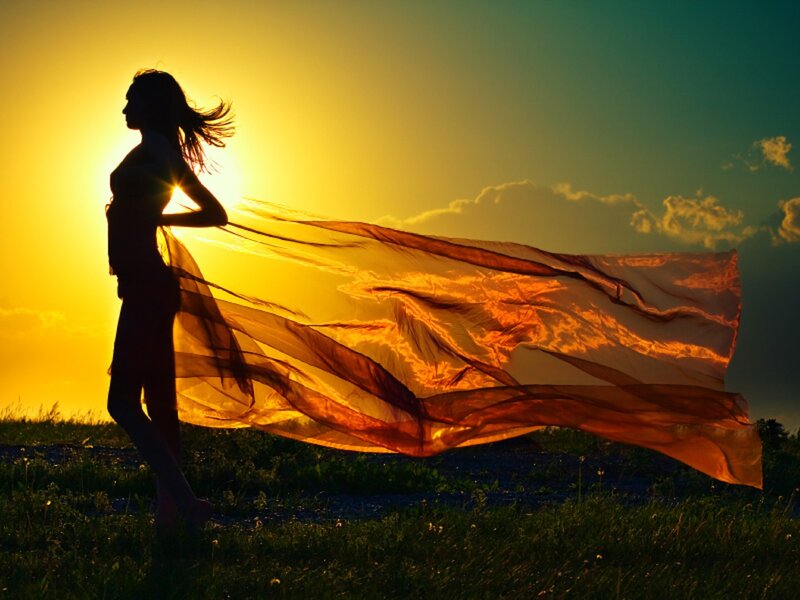 woman with flowing scarf at sunset