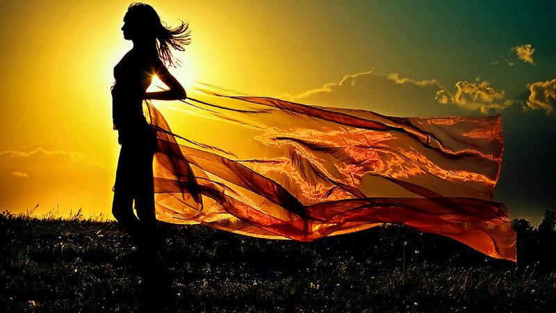 woman with flowing scarf at sunset