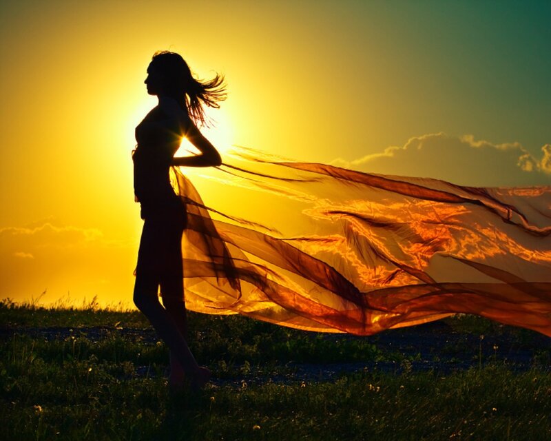 woman with flowing scarf at sunset