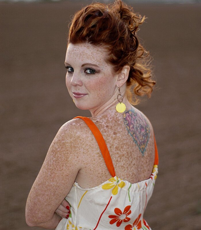 Woman with freckles and tattoo