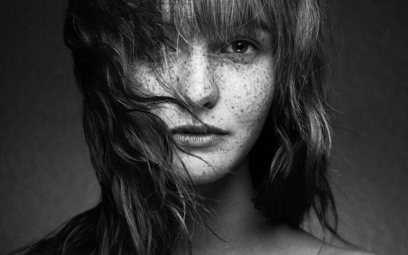 woman with freckles and wind-blown hair