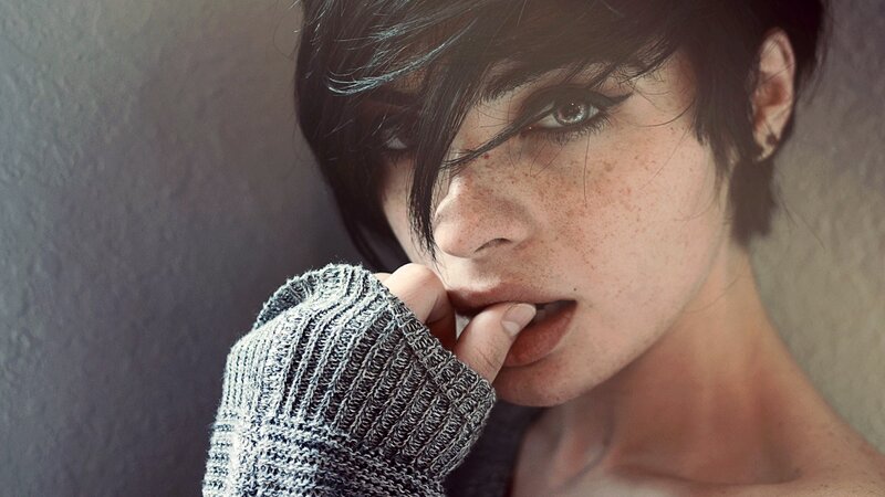 woman with freckles biting finger