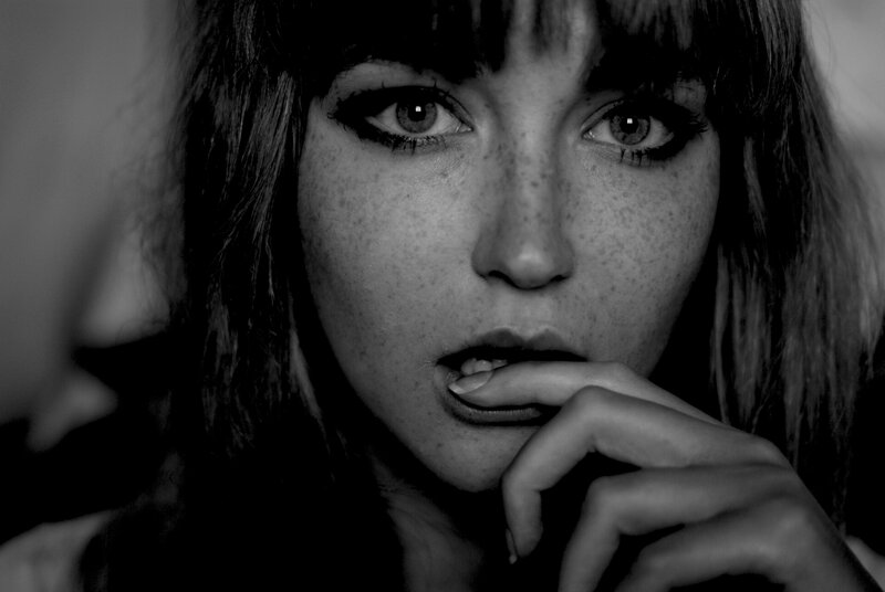 woman with freckles biting finger