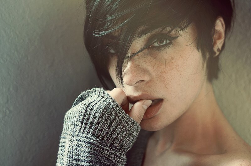 woman with freckles biting finger