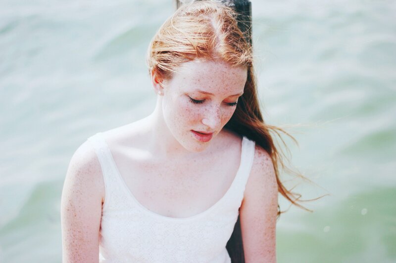 woman with freckles by water