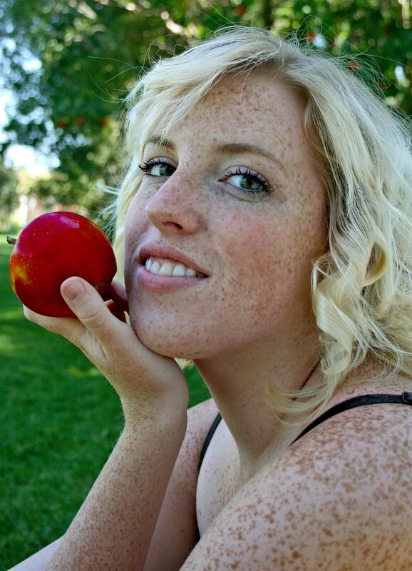 Woman with freckles holding apple