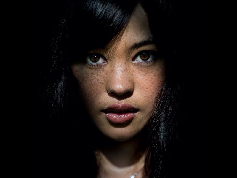woman with freckles in dark light