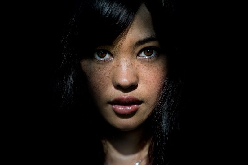 woman with freckles in dark light