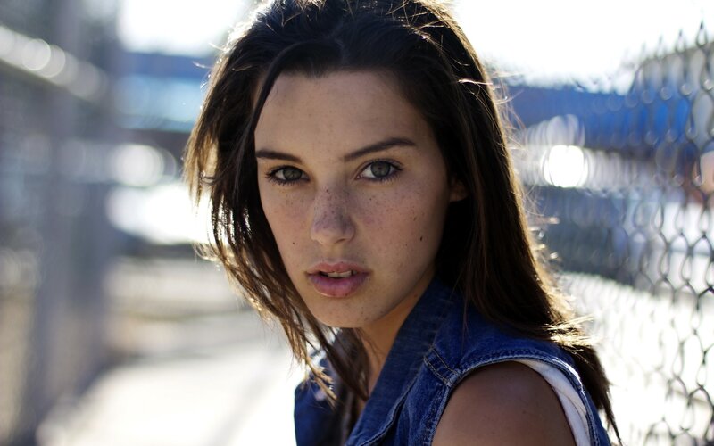 woman with freckles in denim vest