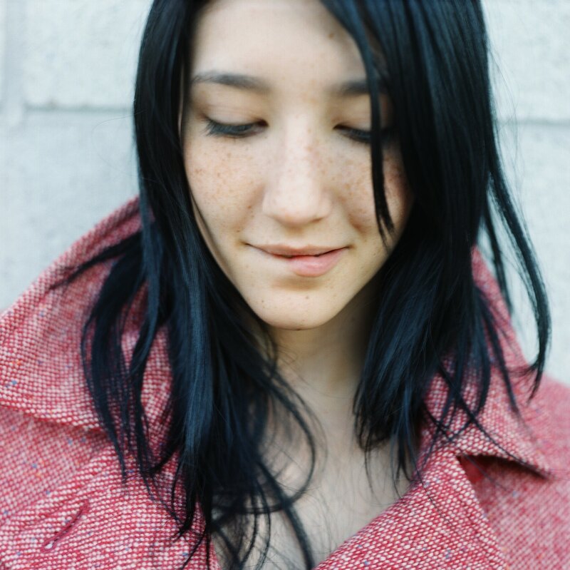 woman with freckles in red coat