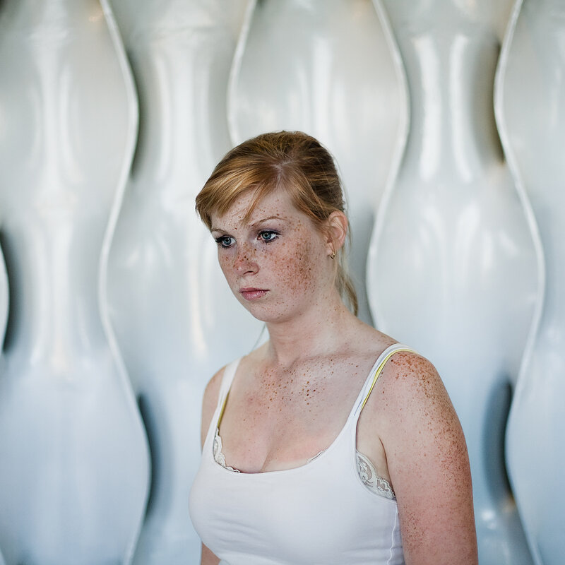 woman with freckles in white top