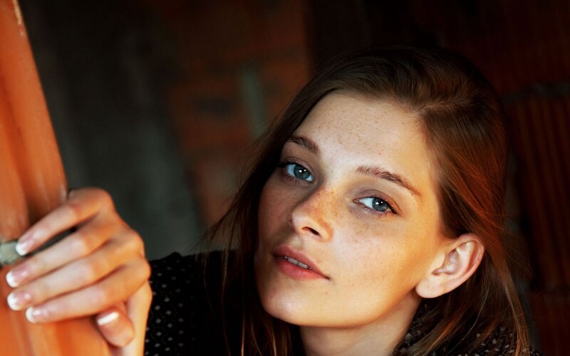 woman with freckles looking at camera