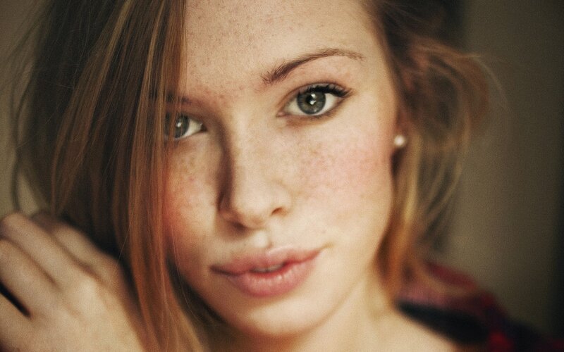 woman with freckles looking at camera