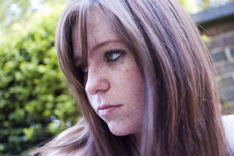 woman with freckles looking away