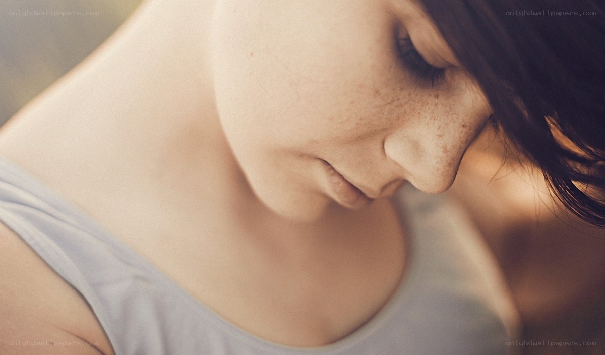 woman with freckles looking down
