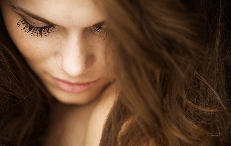 woman with freckles looking down