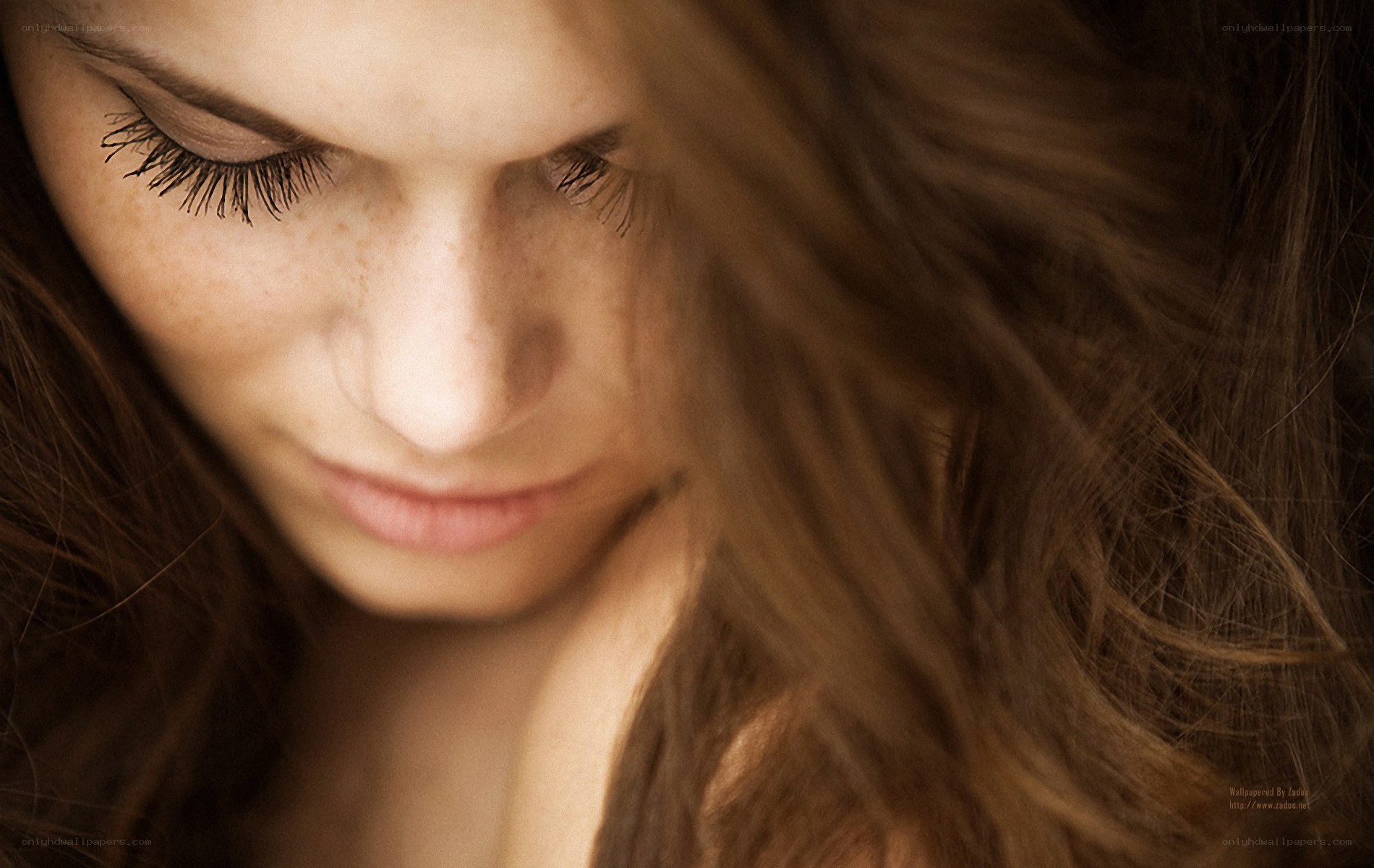 woman with freckles looking down