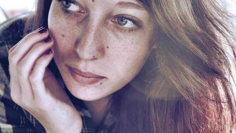woman with freckles on phone